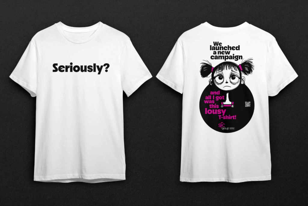 Two white t-shirts displayed front and back against a dark background. The front of the left t-shirt features the word "Seriously?" in large bold black text centered on the chest. The back of the right t-shirt has a large black circular design with pink and white text reading "We launched a new campaign and all I got was this lousy T-shirt!" alongside a cartoon illustration of a sad-faced girl with pigtails tied in pink bows, large eyes, and a downturned mouth. A small QR code is placed near the bottom right of the circle, and the "sfc group healthcare marketing" logo in pink is at the base of the design.